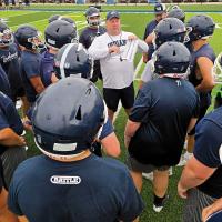 Russell Cook talks with a group of offensive players
