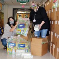 Sheryl Barnett and Kendra Taber unbox school supplies donated to all ERPS students