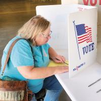 Shana Hurst reads over her ballot question before casting her vote