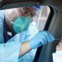 Shannon Baier reacts to getting a nasal swab for a COVID-19 test