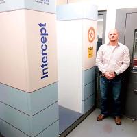 Austin Moore stands beside the new full-body scanner