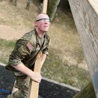 Ryan Sigler looks up for the next wooden beam on an obstacle course