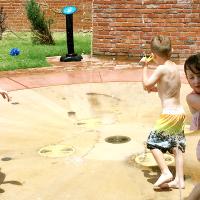 Children play in the splash pad at Youngheim Plaza