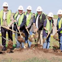 City and state officials turn the ceremonial shovel of dirt at the site