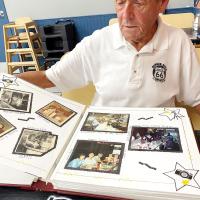 Otis Bruce scans the pages of the scrapbook his wife made for him