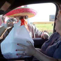 Craig McVay hands a sack of taco dinners to Annie Pearson