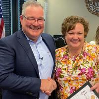 Steve Jensen presents longtime minister Tara Dew with a proclamation recognizing her contributions to the community