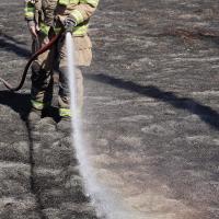 Thomas Vogt hoses down a large patch of burnt farmland