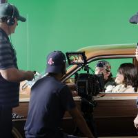 Actors and crew members discuss a scene during filming in El Reno