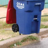 A plastic cup and straw lay just feet from a trash can