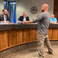 Travis Wilson shows a document to members of the El Reno City Council