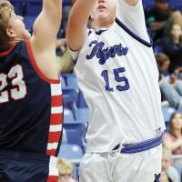 Aiden Williams (15) shoots a hook shot over the outstretched arm of an Asher defender