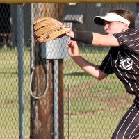 Makenna DeLong has the ball bounce off her glove in foul territory