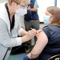 An employee with SSM Health St. Anthony’s gets her first round of the Pfizer vaccine