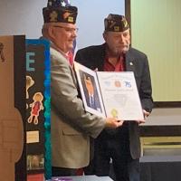 Terry Walker receives an award recognizing the 75-year anniversary of Post 382