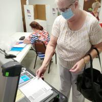 Gladys Lybrand inserts her ballot into the voting machine