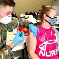 Novella Todd looks away as Jackson Ridgeway administers her vaccination