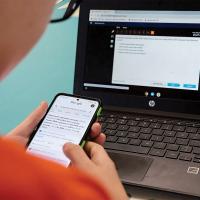 An eighth-grader looks up answers on a cell phone