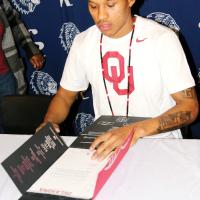 Dorian Plumley reads over the letter of intent he signed with OU