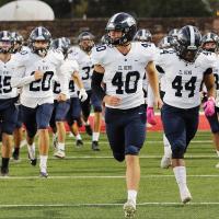 Kolton Hunt and Darius Moore lead teammates onto the field last week