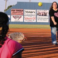Shannon Niles throws out a first pitch to her daughter, Leilani