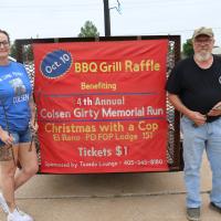 Whitney Sides and Floyd “Ribeye” Mullen show off the grill that will be raffled off