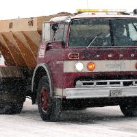 A truck spreads sand along State Highway 66
