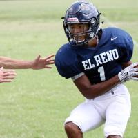 Gana Nicholson tries to dodge a tackler while clutching the football after catching a swing pass.