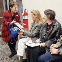 Karen Nance gives a photo of the late Mayor Herman Dittmer to Diane Maxey, his granddaughter and her mother, Marie Stover, his daughter