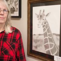 Sue Smith stands next to her original art