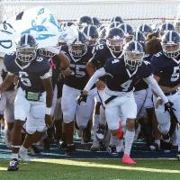 Members of the EHS football team run onto the ﬁeld 