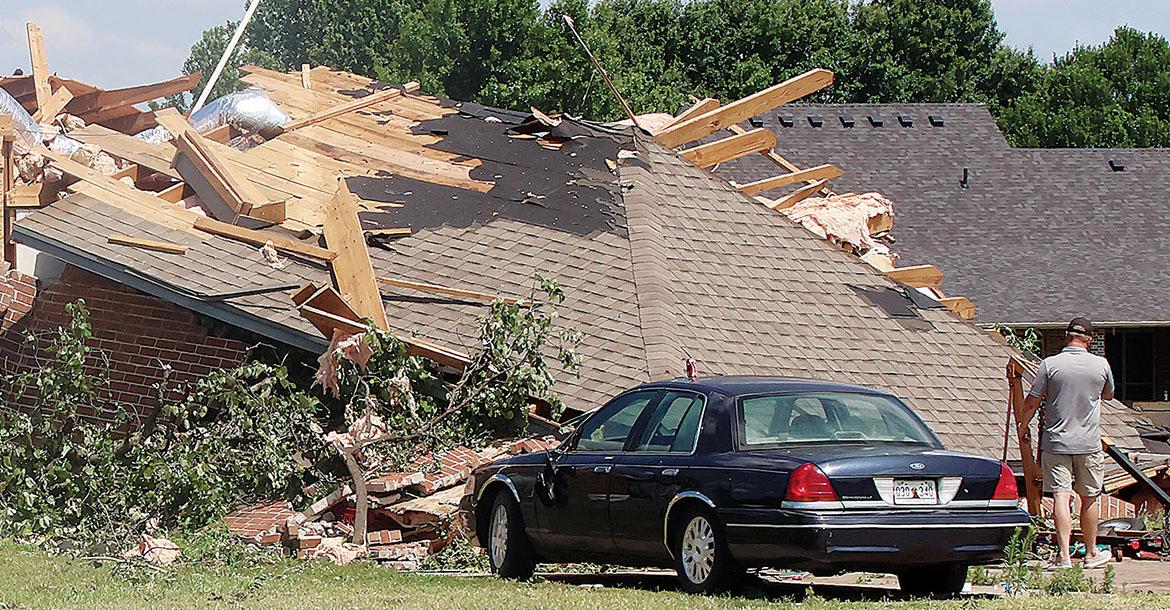 A storm repairman inspects a damaged home_slideshow