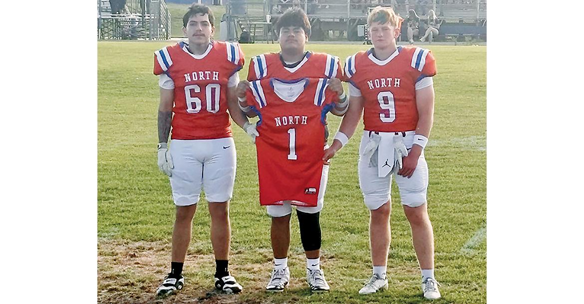 Omar Tristan (60), Jaron Youngbear and Rustyn Cook (9) carried Brad Palmer’s jersey during introductions_slideshow