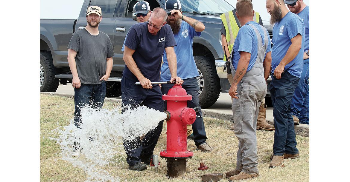 Jason Duff watches a spray of water shoot out of a hydrant along Jensen Road_slideshow