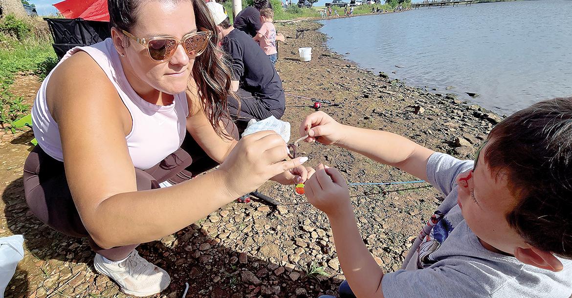 Bailey Gilbert helps her nephew, Brayton Jones put a worm on a hook_slideshow