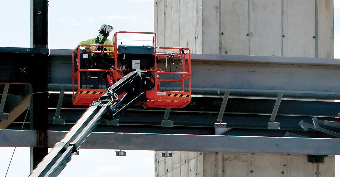 A construction worker uses a crane to work on a piece of steel_slideshow
