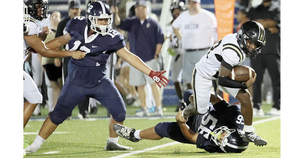 Eli Medellin (56) makes an ankle tackle on a Midwest City runner as Jaylen Ferguson (12) tries to fight off a blocker_slideshow