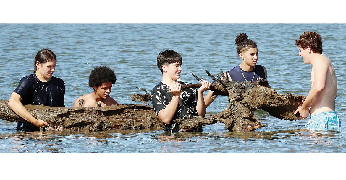 El Reno High School football players lift up a tree from the bottom of Lake El Reno_slideshow