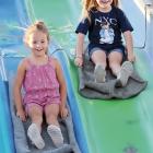 Paislee Stamper (left) and A.J. Western laugh while sliding down the sack race course
