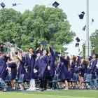 Graduates throw their caps into the air