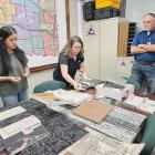 Adaly Guasso, and Tayler Thompson display samples of wall and flooring materials to Tomas Manske
