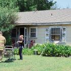 El Reno firefighters get instructions before helping wheel in an empty gurney into this home