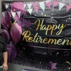 Becky Wahler stands next to her retirement party banner