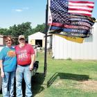 Floyd and Toni Mullens pose next to the flag that greeted first responders