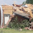 A storm repairman inspects a damaged home
