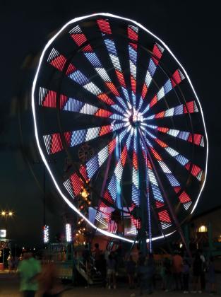 The Ferris wheel from Great Plains Amusement lights up the night sky