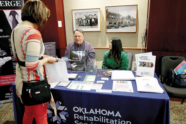 A woman talks with staff of the Oklahoma Department of Rehabilitation Services