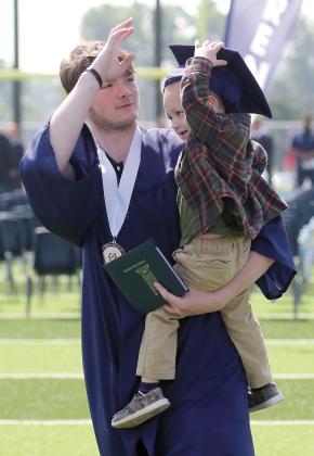 Graduate Zane Wilson helps his nephew Clyde try on his cap