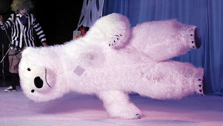A fuzzy polar bear spins circles on one hand