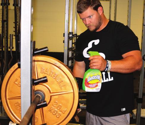 Austin Feddersen sprays down disks in the weight room